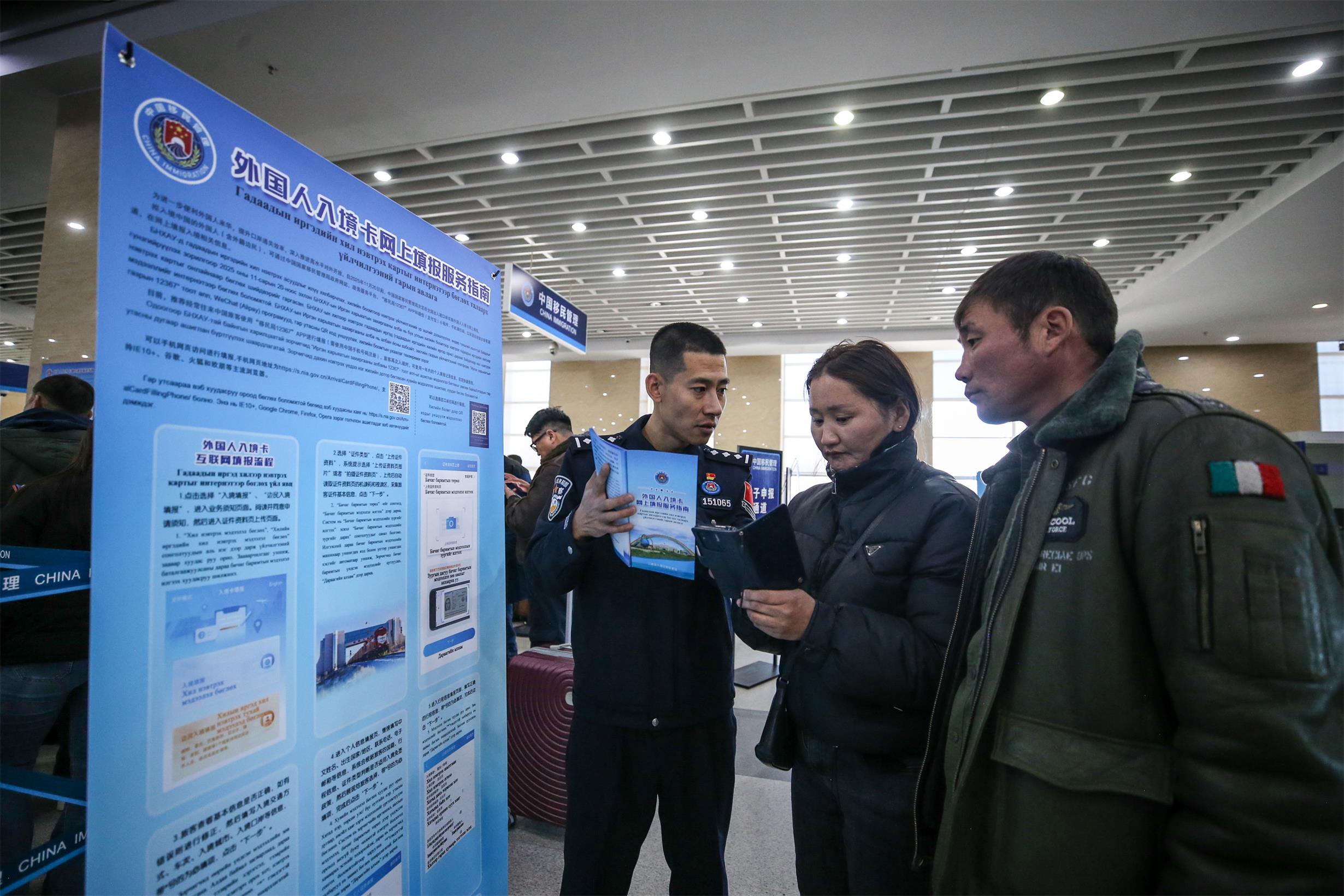 1763623392885059765.jpg 图5:2025年11月20日,二连出入境边防检查站移民管理警察为旅客讲解外国人入境卡网上填报流程。.jpg