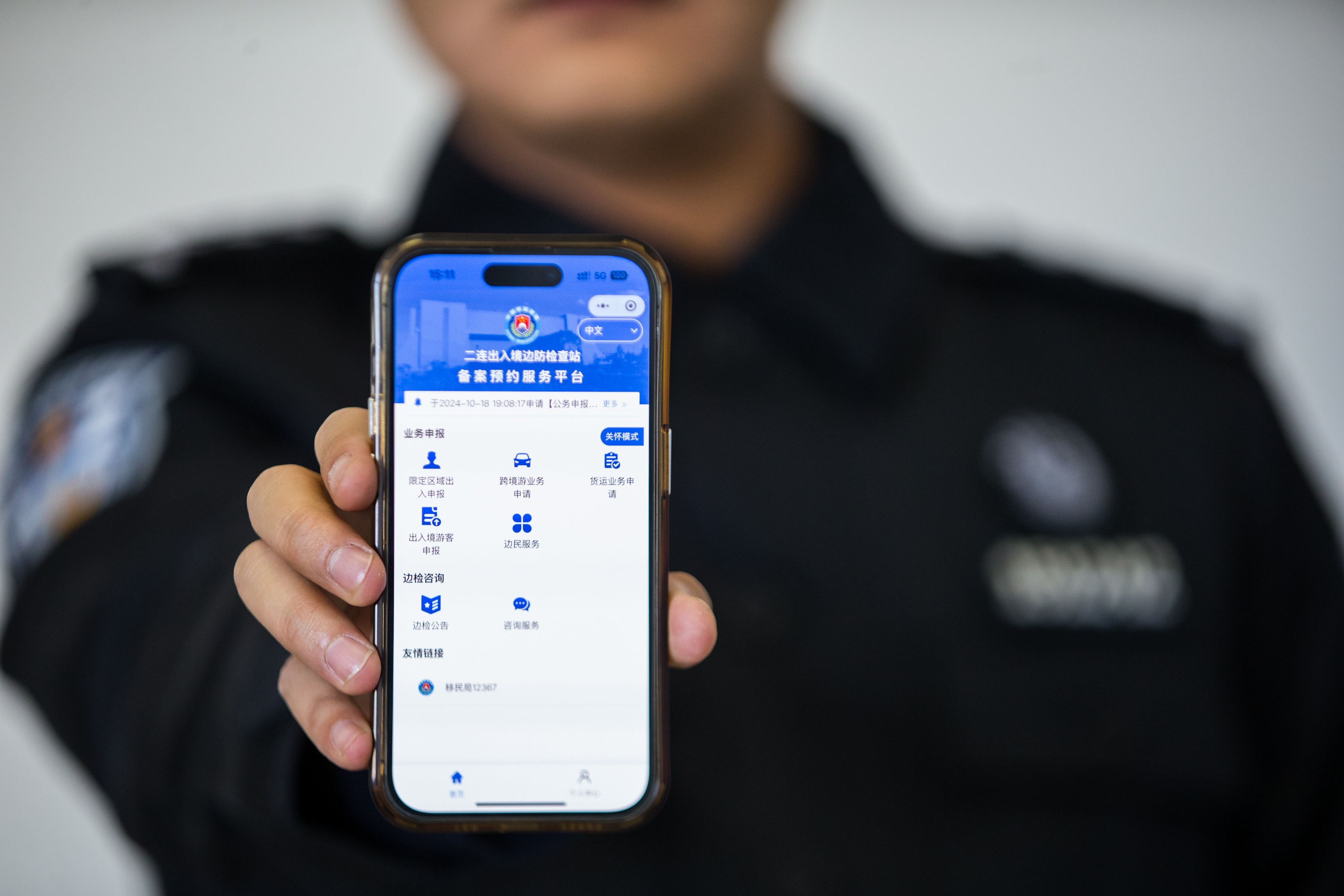 图1：二连出入境边防检查站执勤民警展示“边检通”备案预约服务平台(1).jpg